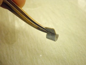 ピンセットで紙やすりをつまんでいる様子